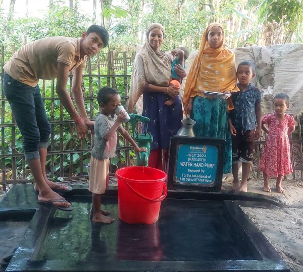 A hand pump drawing clean water from the ground, providing a vital water source for the community.