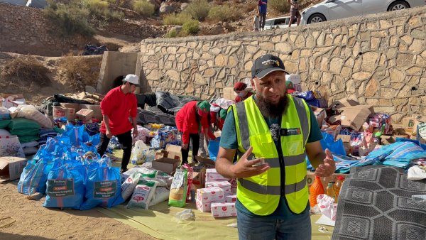 A photograph of relief workers distributing essential supplies to needy families in Morocco.